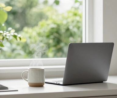 A closed laptop on a kitchen counter beside a steaming mug and an open window showing a green garden